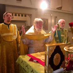 Trzech duchownych w bogato zdobionych szatach podczas iii modlitwy eucharystycznej. Na stole księga z ozdobną oprawą.
