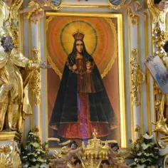 Złote rzeźby świętych otaczają obraz Matki Bożej Kodeńskiej. Wierni modlą się do niej, szukając pocieszenia i łaski.