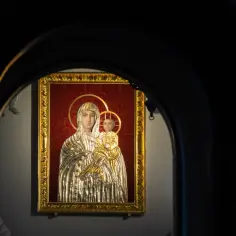 Ikona Matki Boskiej Śnieżnej w złotej ramie, widziana przez ciemny łuk.