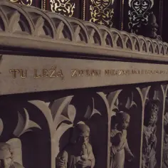 Kamienny sarkofag z napisem "TU LEŻĄ ZWŁOKI MIECZYSŁAWA II" i płaskorzeźbami postaci. Jutrznia za zmarłego.