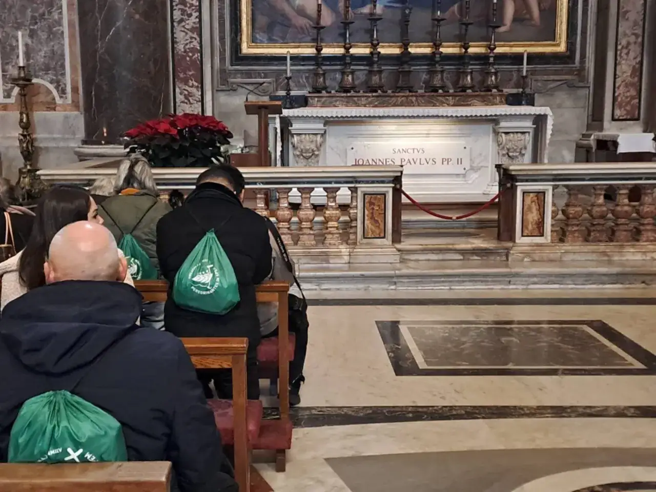 Pielgrzymi w zielonych torbach modlą się przy grobie św. Jana Pawła II. To ważny rok jubileuszowy w kościele.
