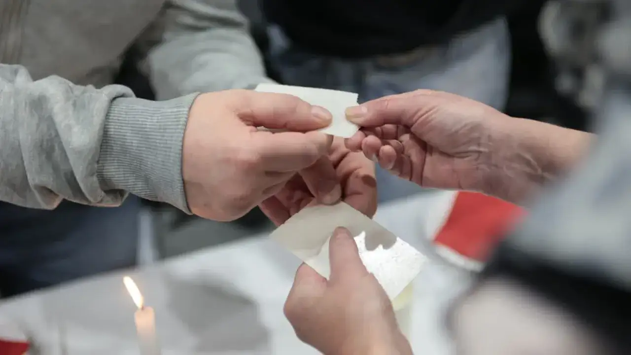Dzielenie się opłatkiem to ważny element modlitwy przed wieczerzą wigilijną. Dłonie przekazują sobie białe, kruche kawałki.